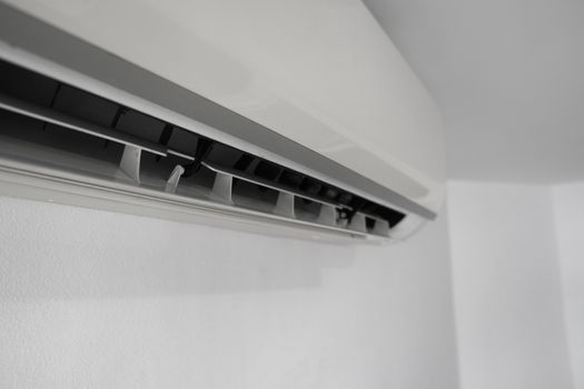 Air conditioner mounted on a white wall in the living room or bedroom. Indooor comfort temperature. Health concepts and energy savings