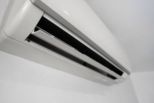 Air conditioner mounted on a white wall in the living room or bedroom. Indooor comfort temperature. Health concepts and energy savings