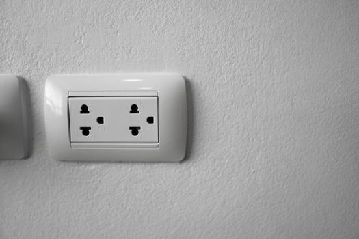 White universal electricity sockets plug on a white wall
