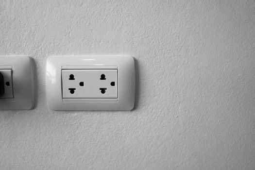 White universal electricity sockets plug on a white wall