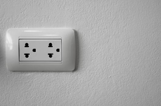 White universal electricity sockets plug on a white wall