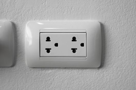 White universal electricity sockets plug on a white wall