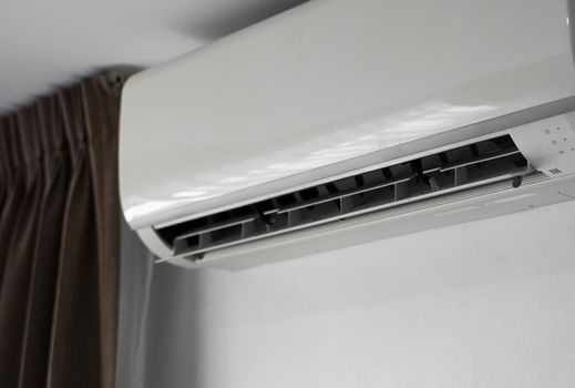 Air conditioner mounted on a white wall in the living room or bedroom. Indooor comfort temperature. Health concepts and energy savings