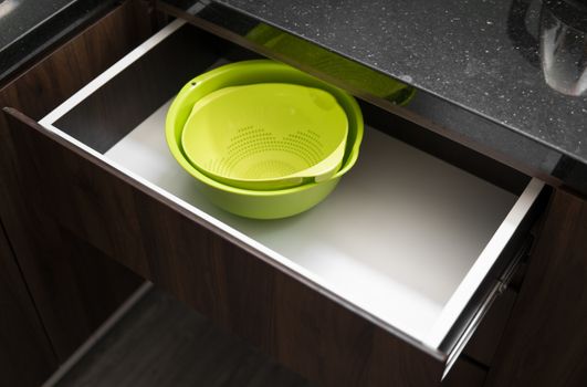 Green salad bowl and bowl for straining food from water in the kitchen drawer