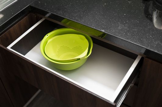 Green salad bowl and bowl for straining food from water in the kitchen drawer