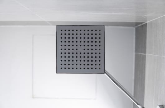 Square shower head in a modern bathroom. Shower in the bathroom with water spray or water. Feel relaxed and enjoy in the bathroom. A stream of fresh water from the shower head to clean the dirty body