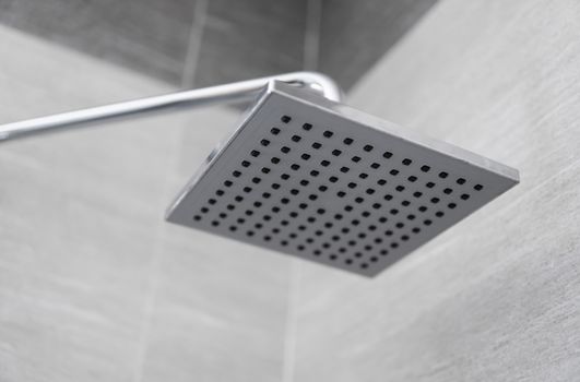 Square shower head in a modern bathroom. Shower in the bathroom with water spray or water. Feel relaxed and enjoy in the bathroom. A stream of fresh water from the shower head to clean the dirty body