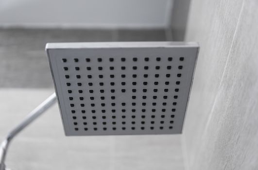 Square shower head in a modern bathroom. Shower in the bathroom with water spray or water. Feel relaxed and enjoy in the bathroom. A stream of fresh water from the shower head to clean the dirty body