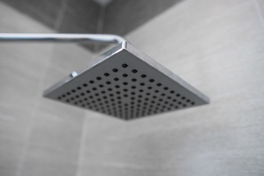 Square shower head in a modern bathroom. Shower in the bathroom with water spray or water. Feel relaxed and enjoy in the bathroom. A stream of fresh water from the shower head to clean the dirty body
