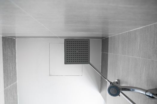 Square shower head and classic shower head in a modern bathroom. Shower in the bathroom with water spray or water. A stream of fresh water from the shower head to clean the dirty body