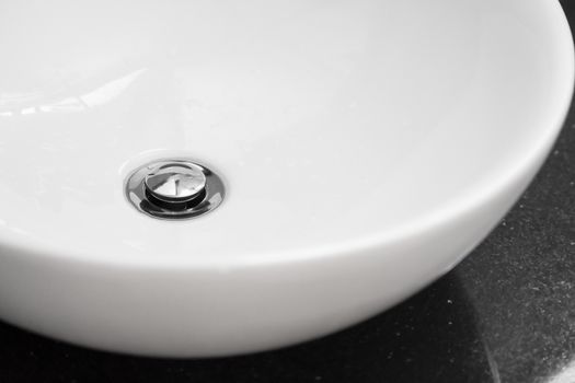 Bathroom interior with white round sink and chrome faucet in a modern bathroom