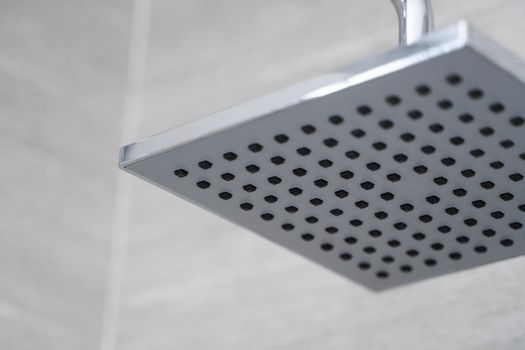 Square shower head in a modern bathroom. Shower in the bathroom with water spray or water. Feel relaxed and enjoy in the bathroom. A stream of fresh water from the shower head to clean the dirty body