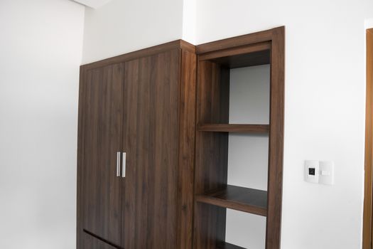 Modern brown wooden wardrobe in the room