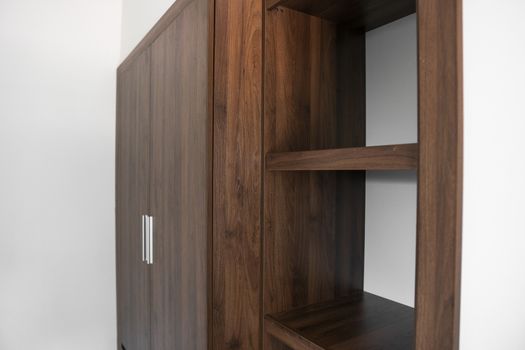 Modern brown wooden wardrobe in the room