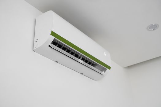 Air conditioner mounted on a white wall in the living room or bedroom. Indooor comfort temperature. Health concepts and energy savings