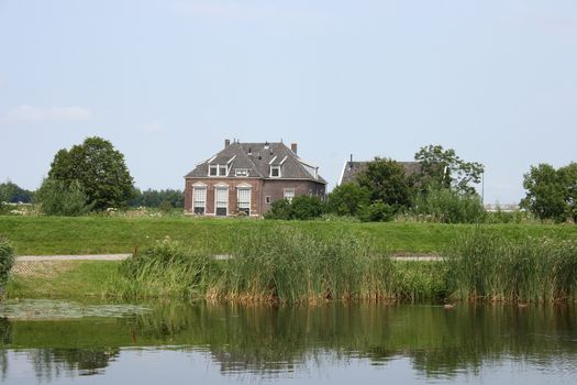 Lonely old House, with a body of water in the foreground 