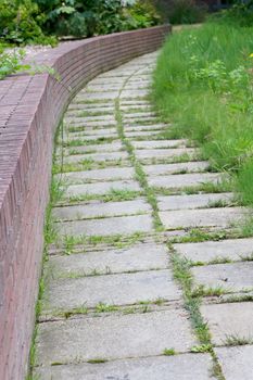 paved path to a brick wall along