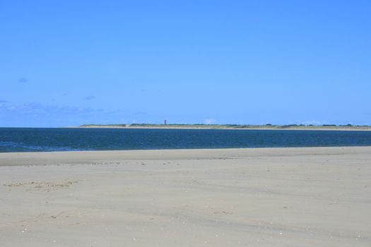 Sandy beach with sea and blue sky background