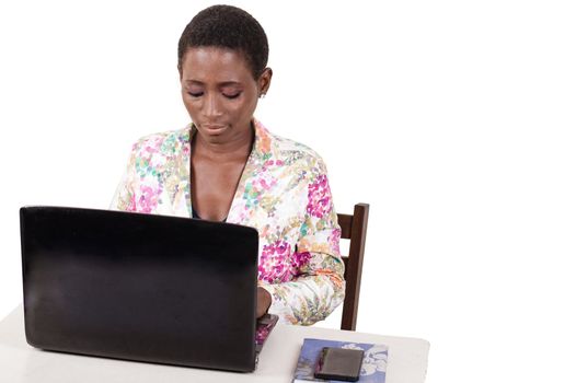 Young woman sitting in office working on laptop