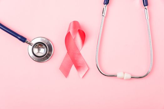 Breast Cancer Awareness Month Health concept, top view flat lay pink ribbon and stethoscope on pink background with copy space for your text