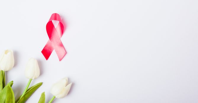 Breast cancer month concept, flat lay top view, pink ribbon and Tulip Flower on white background with copy space for your text