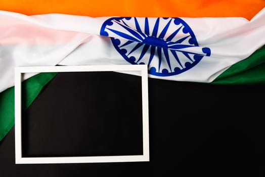 Indian republic day, flat lay top view, Indian flag and photo frame on black background with copy space for your text