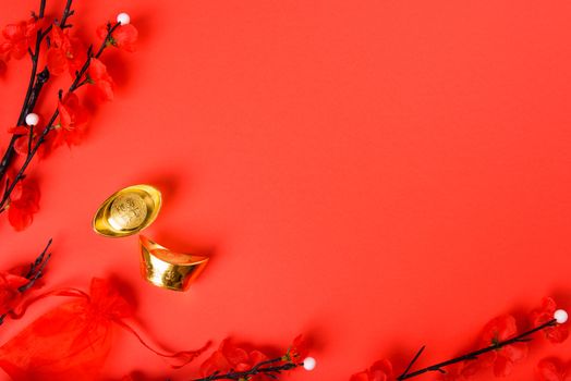 Chinese New Year, flat lay top view, gold bar and Chinese Flower on red background with copy space for your text