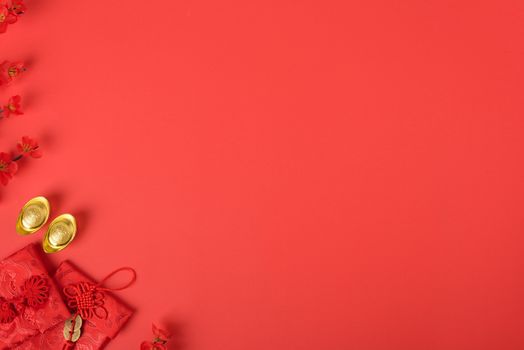 Chinese new year concept, flat lay top view, Happy Chinese new year with Red envelope and gold ingot (Character "FU" means fortune, blessing, wealth) on red background with copy space for your text
