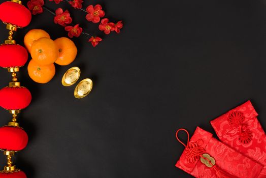 Chinese new year festival concept, flat lay top view, Happy Chinese new year with Red envelope and gold ingot (Character "FU" means fortune, blessing) on black background with copy space for text