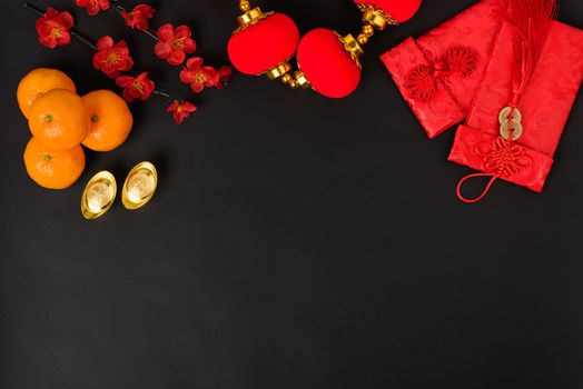Chinese new year festival concept, flat lay top view, Happy Chinese new year with Red envelope and gold ingot (Character "FU" means fortune, blessing) on black background with copy space for text