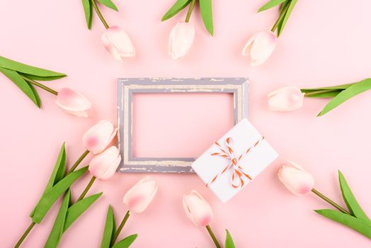 Happy Women's Day, Mother's Day concept. top view flat lay photo frame, gift box and Tulip flower on pink background, copy space for your text