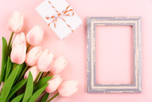 Happy Women's Day, Mother's Day concept. top view flat lay photo frame, gift box and Tulip flower on pink background, copy space for your text