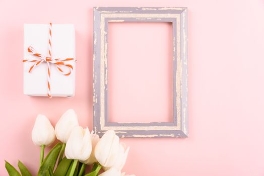 Happy Women's Day, Mother's Day concept. top view flat lay photo frame, gift box and Tulip flower on pink background, copy space for your text