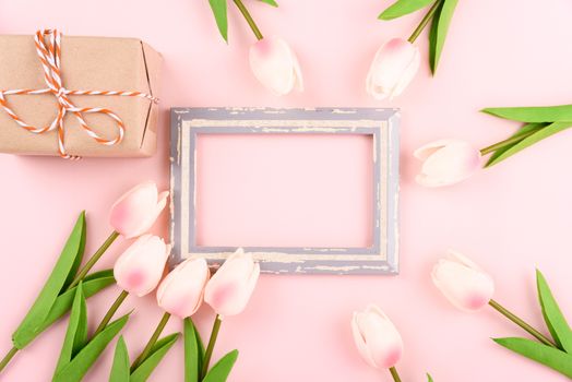 Happy Women's Day, Mother's Day concept. top view flat lay photo frame, gift box and Tulip flower on pink background, copy space for your text