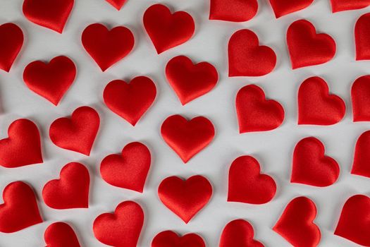 Valentine's day many red silk hearts on white background, love concept