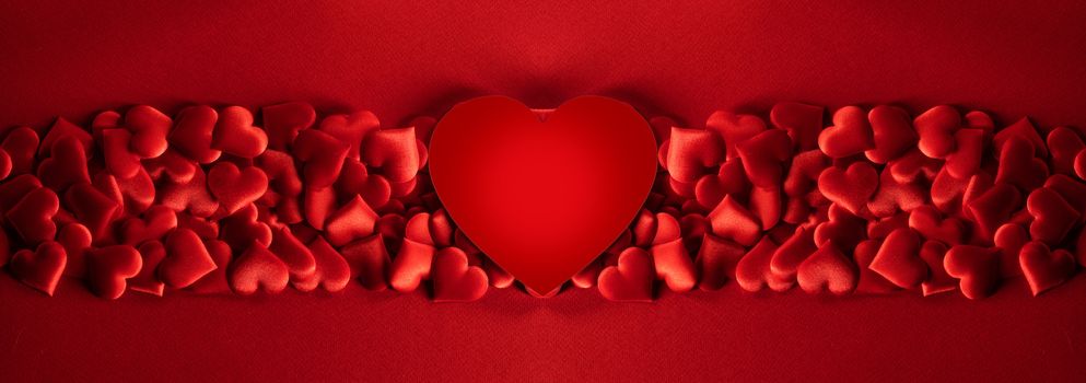 Valentine's day many red silk hearts and big heart shaped paper card background , border frame on red with copy space, love concept