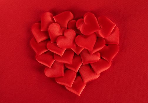 Valentine's day many red silk hearts ob paper background, love concept