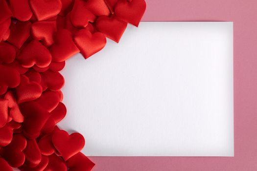 Valentine's day many red silk hearts background , border frame with white card with copy space, love concept