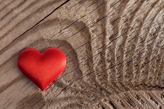 Valentine's day red silk heart on wooden background, love concept