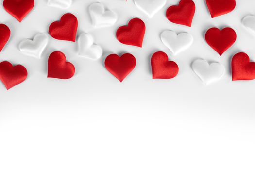 Valentine's day many red and white silk hearts on white background , border frame with copy space, love concept