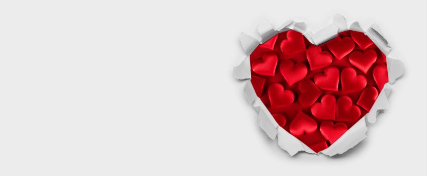 Torn white paper heart over red hearts background with copy space for text, Valentine's day love concept