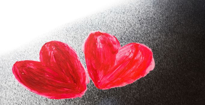 Two abstract red painted hearts on metal background