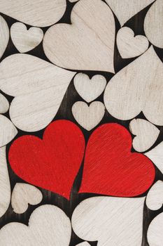 Many wooden colorless hearts background, two red special ones true love concept