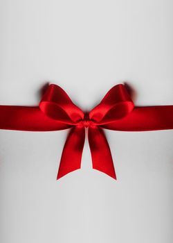 Red satin ribbon bow on white background