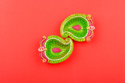 Happy Diwali Day, Flat lay top view Colorful Clay Diya lamps on red background and copy space for your text