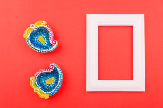 Happy Diwali Day, Flat lay top view Colorful Clay Diya lamps and photo frame on red background and copy space for your text