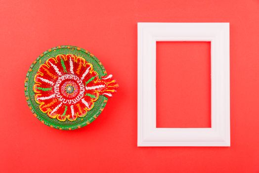 Happy Diwali Day, Flat lay top view Colorful Clay Diya lamps and photo frame on red background and copy space for your text