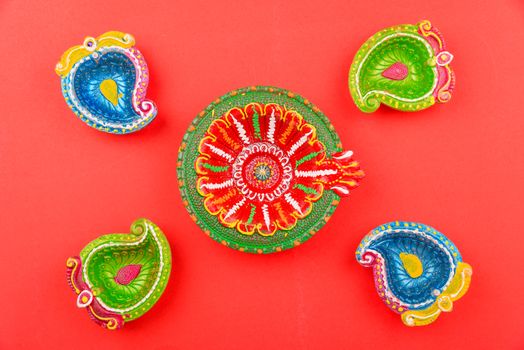 Happy Diwali Day, Flat lay top view Colorful Clay Diya lamps on red background and copy space for your text