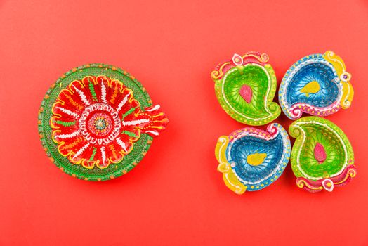 Happy Diwali Day, Flat lay top view Colorful Clay Diya lamps on red background and copy space for your text