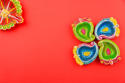 Happy Diwali Day, Flat lay top view Colorful Clay Diya lamps on red background and copy space for your text